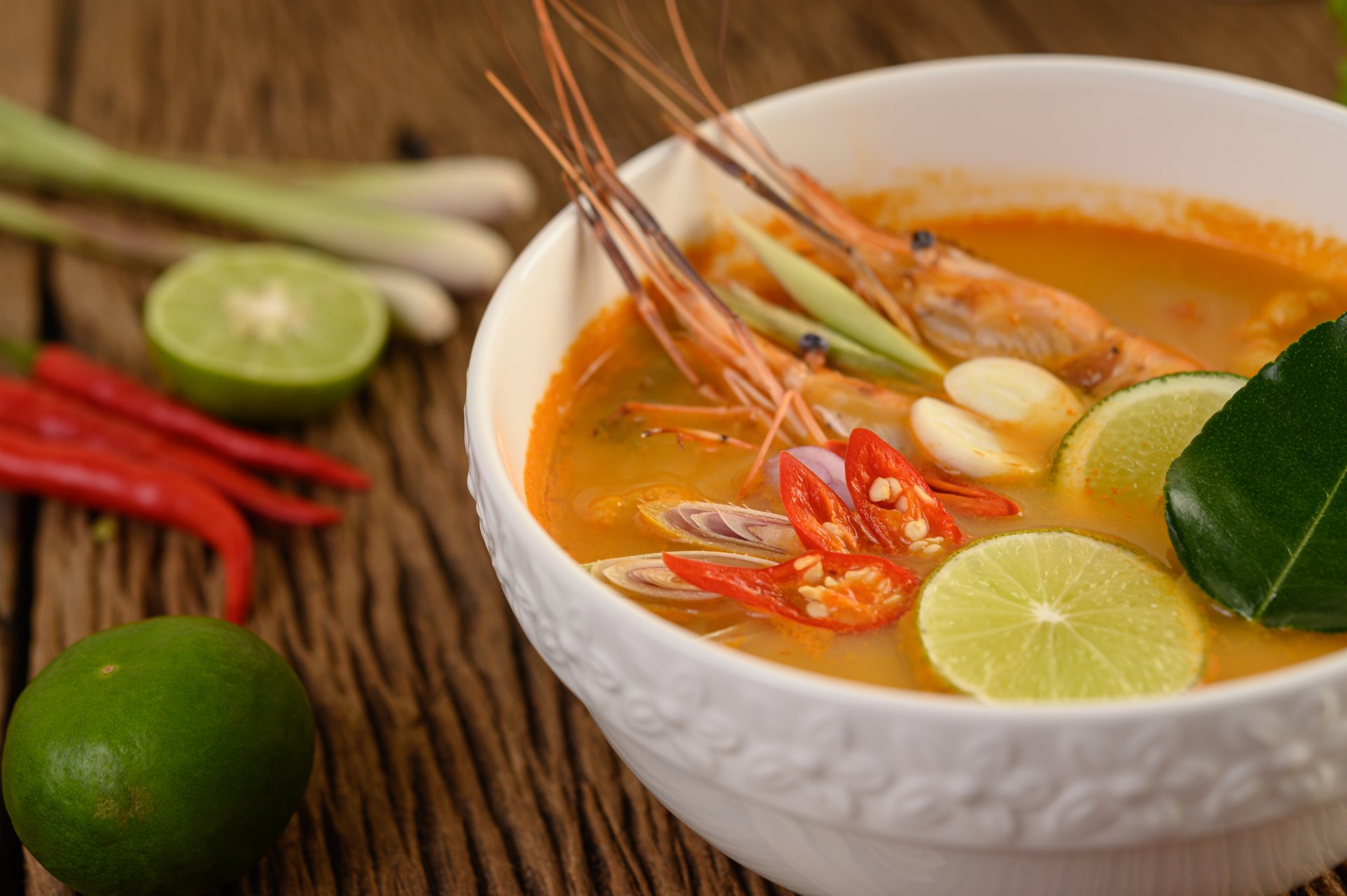 Tom Yum Kung Thai hot spicy soup shrimp with lemon grass,lemon,galangal and chilli on wooden background Thailand Food